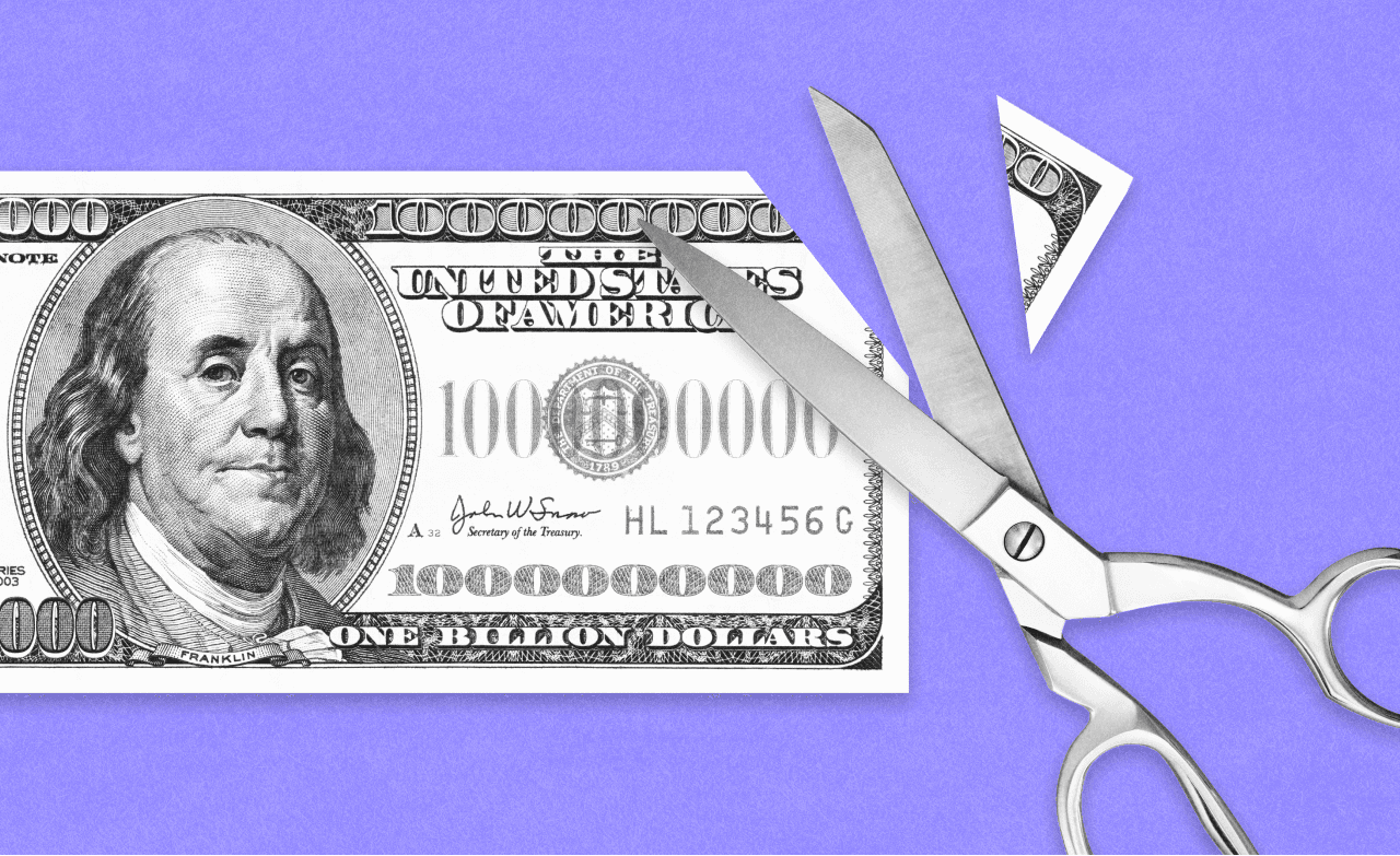 Scissors cutting a one-billion-dollar bill
